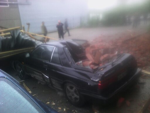 В Кемерове во время урагана упавшие со здания кирпичи расплющили Nissan